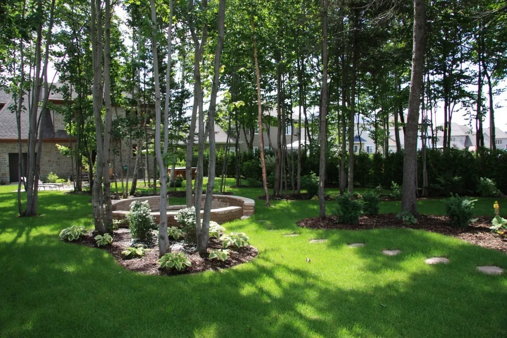 Grand terrain aménagé avec pelouse, arbres et plates-bandes